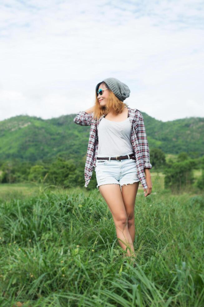 mulher jovem e bonita hipster de braços cruzados em meio a natureza e montanha, conceito relaxante foto