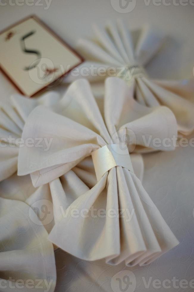 mesa decorada lindamente elegante para férias - casamento ou dia dos namorados com talheres modernos, arco, vidro, vela e presente, closeup, tonificado foto