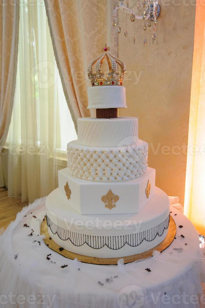 bolo de casamento com luxo decorado em festa de casamento. bolo decorado com coroa foto