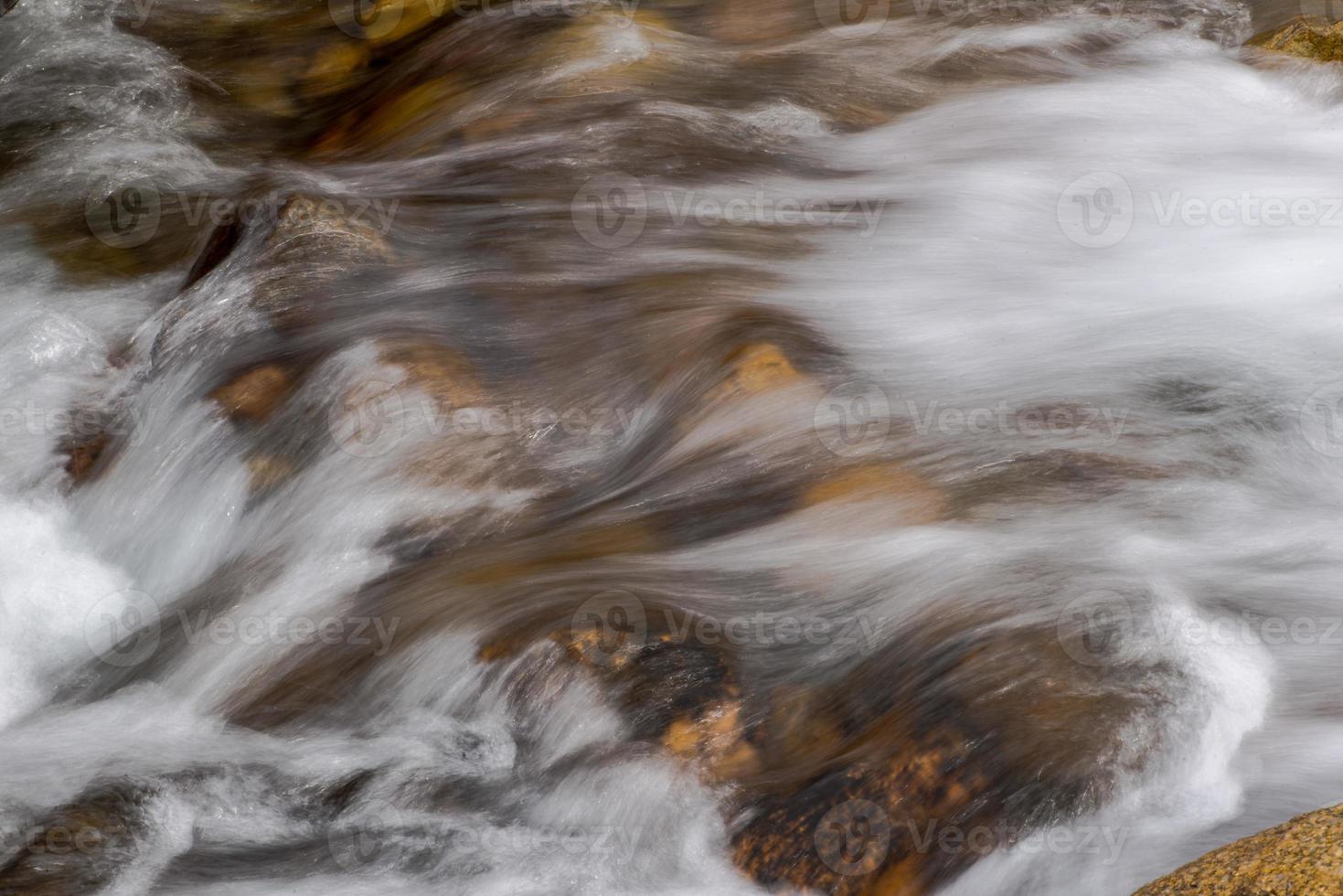 fluxo de um rio de montanha com pedras arredondadas foto