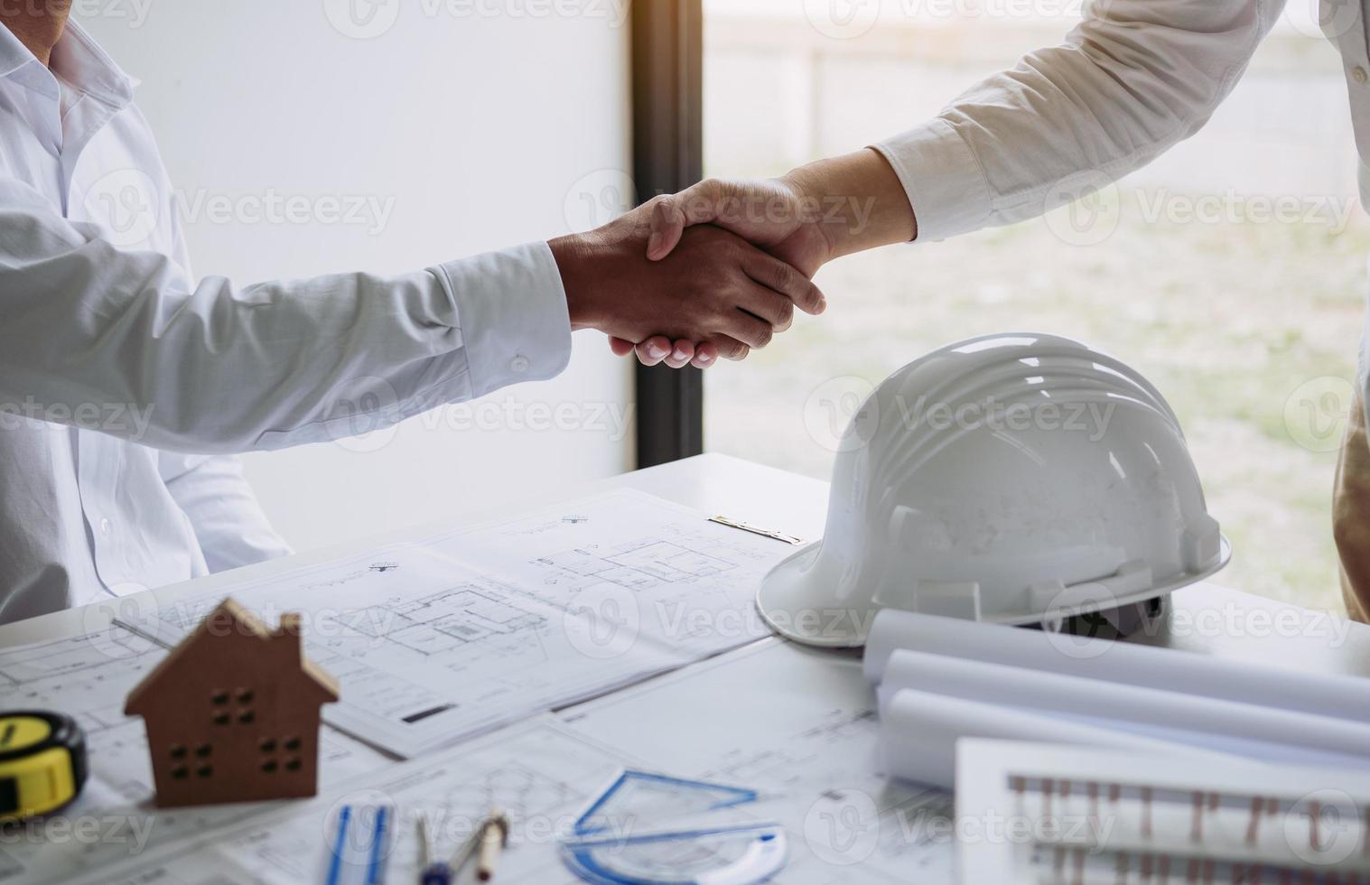 dois homem de engenharia com trabalhador da construção civil cumprimentando um capataz na renovação do apartamento. foto