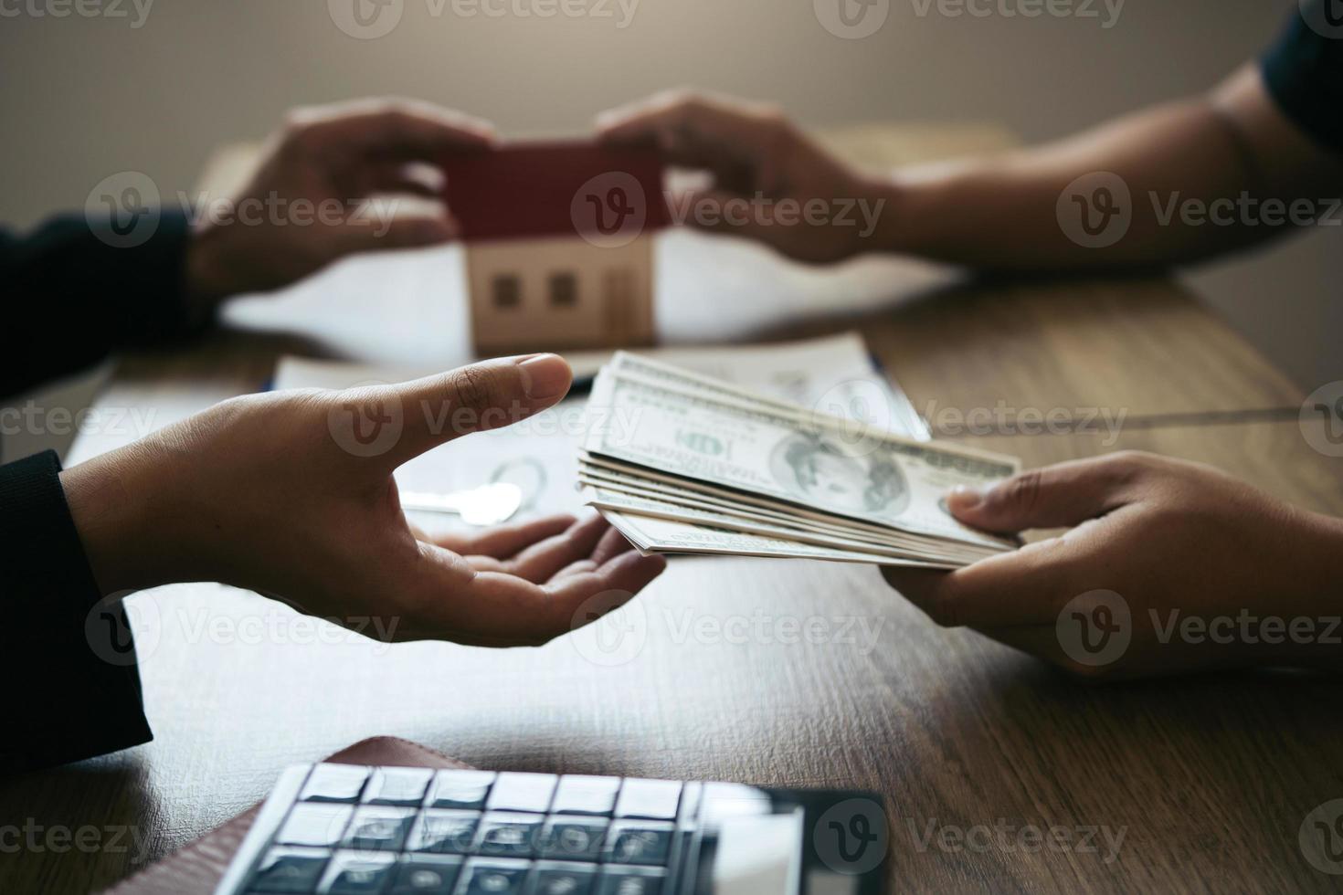 corretores de vendas de casas e investidores imobiliários estão trocando com os investidores que estão depositando dinheiro na mão do agente. foto
