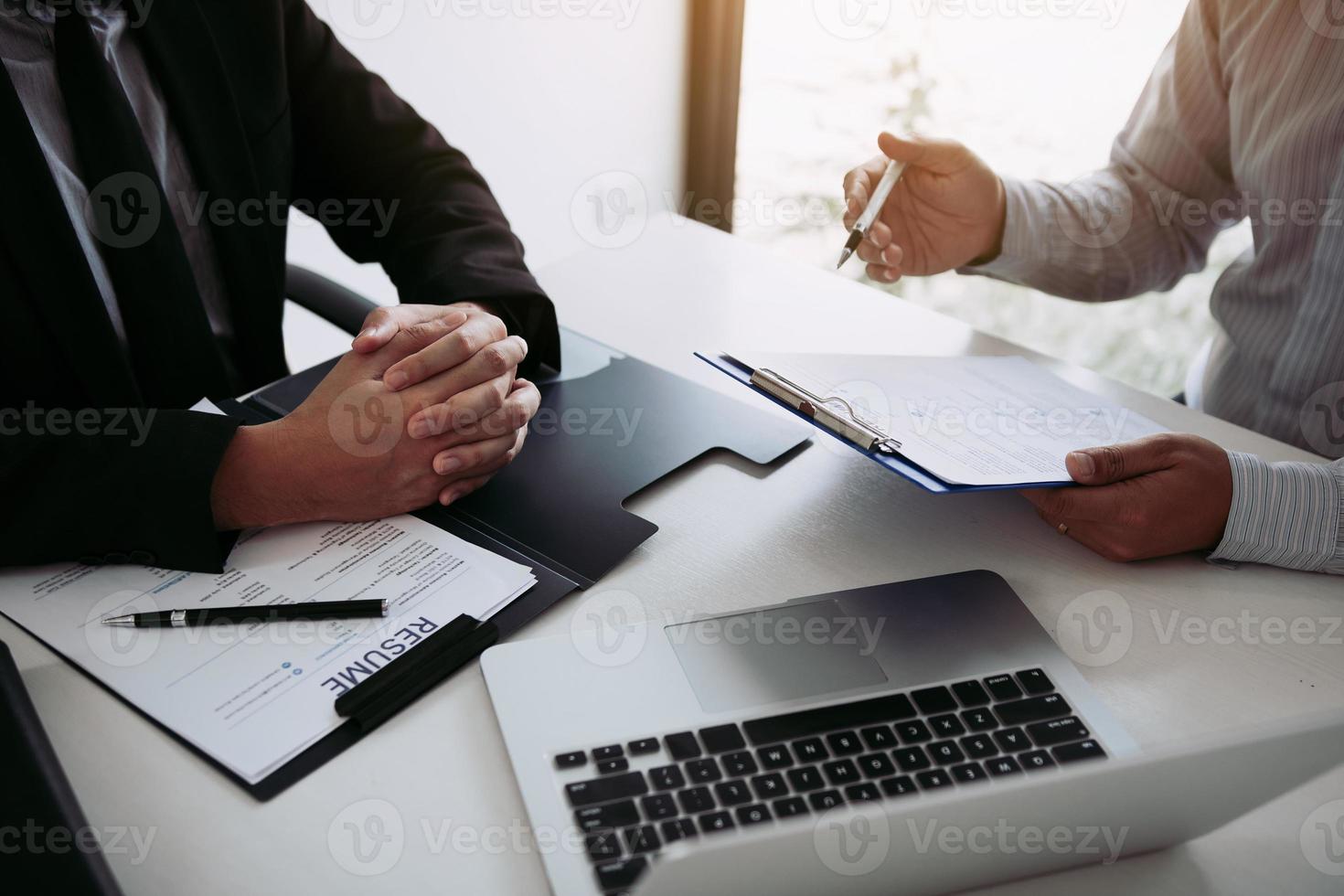 os homens estão descrevendo o histórico de emprego do empregador sobre sua experiência de trabalho. foto