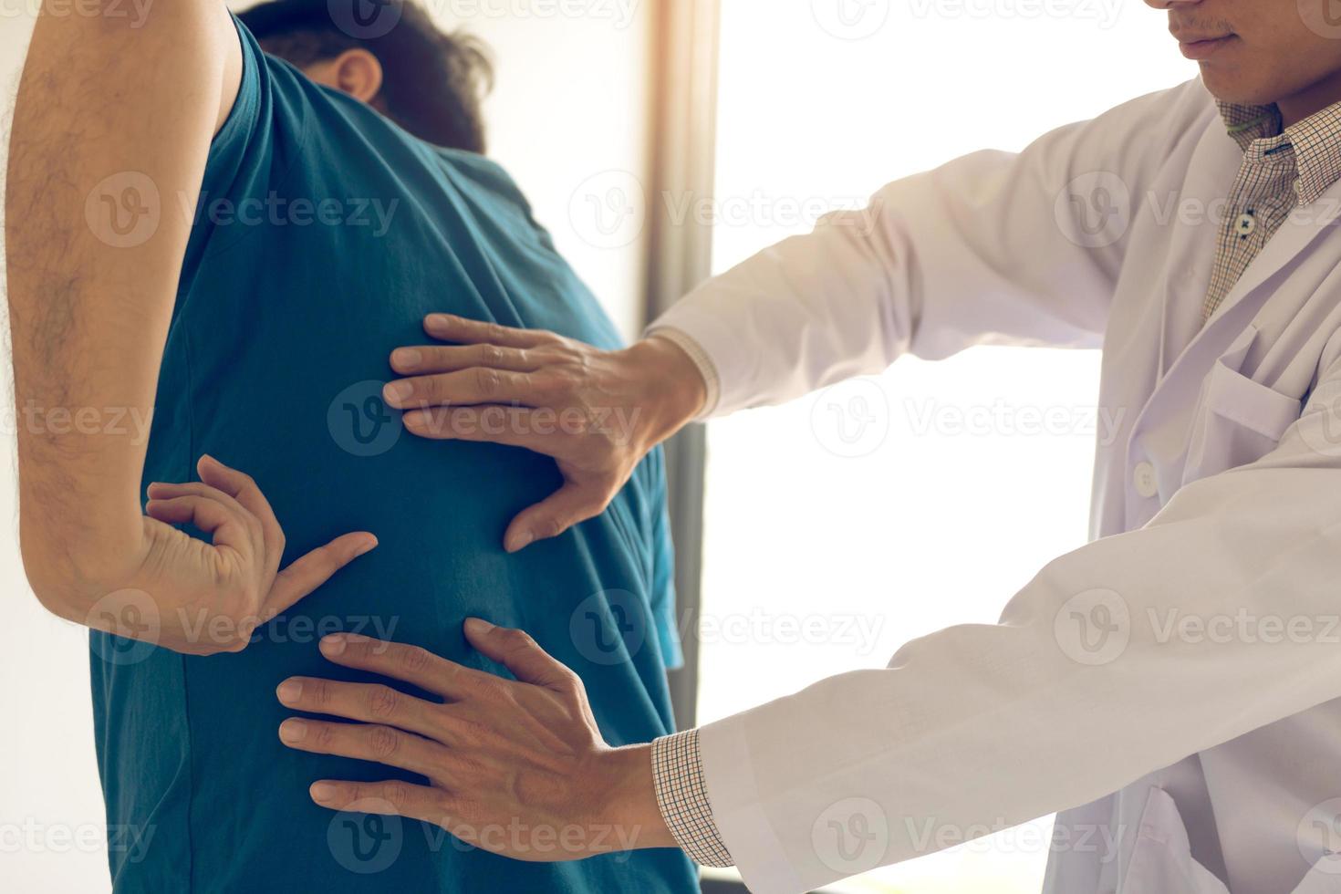 paciente está apontando para o ponto onde a dor muscular é fornecida ao fisioterapeuta para verificar. foto