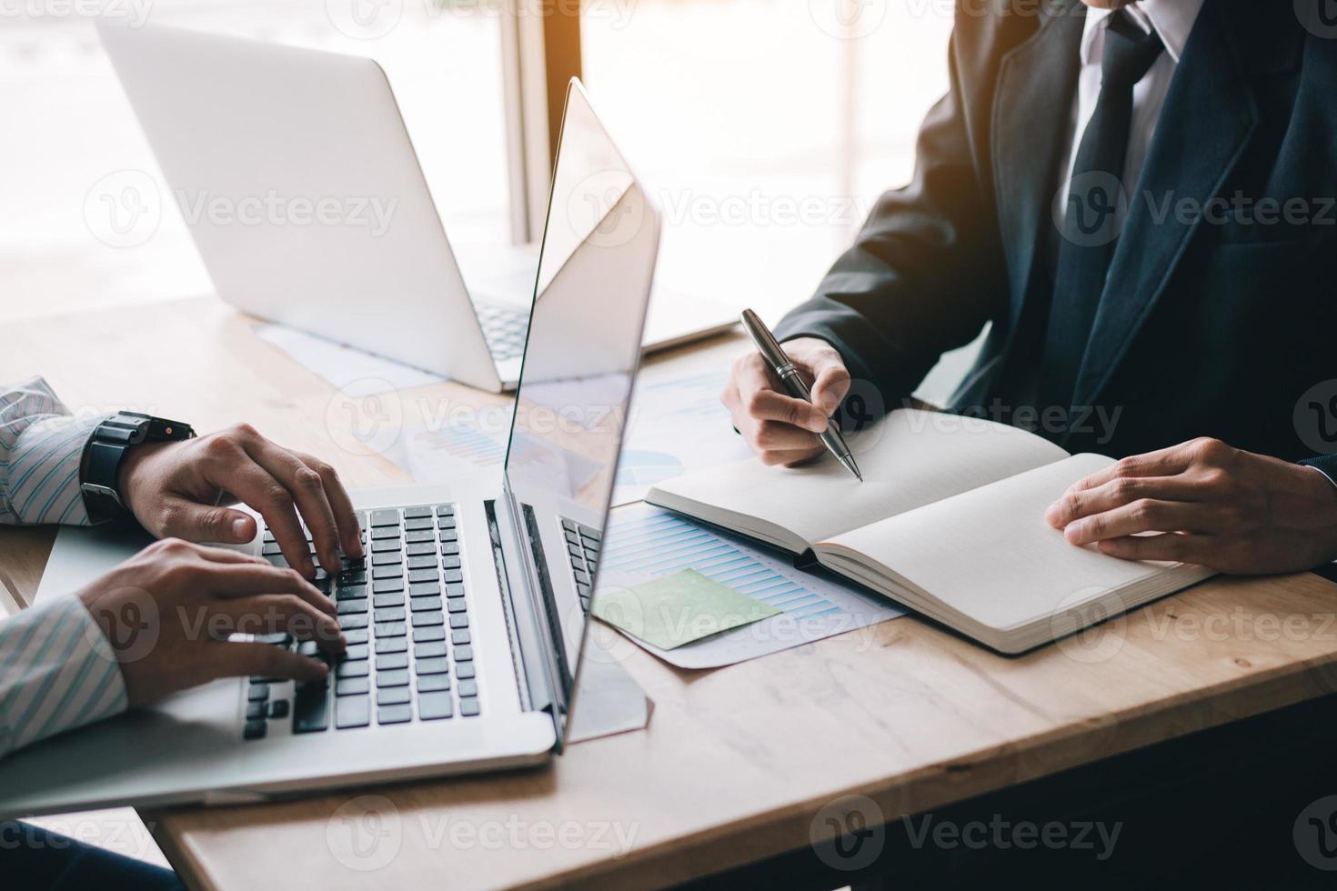 equipe de dois empresários calcula sobre o relatório resumido anual no escritório de mesa. foto