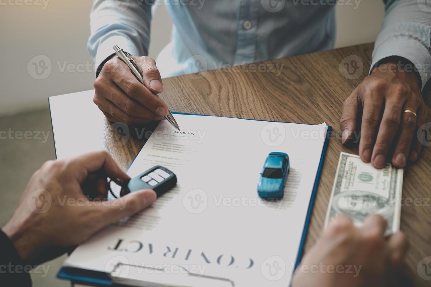 compradores de carros novos estão assinando um contrato com um vendedor de carros no showroom no dia de receber o carro e entregar o dinheiro ao funcionário. foto