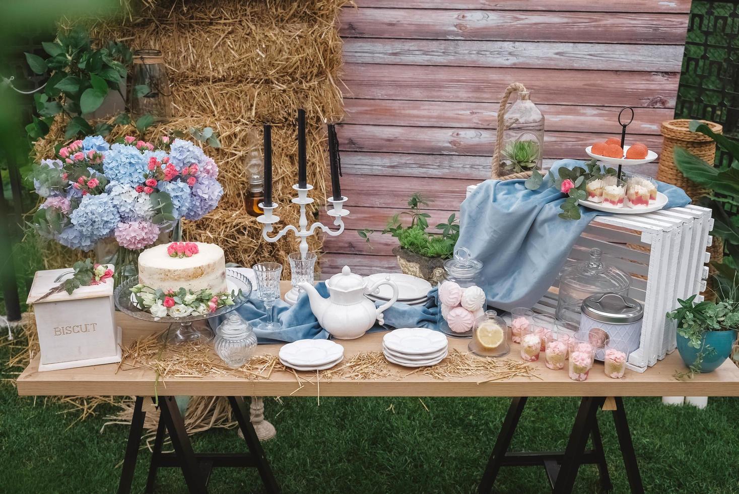 bombom de casamento em estilo rústico decorado com pratos, talheres, copos, velas e arranjos de flores. copiar, espaço vazio para texto foto