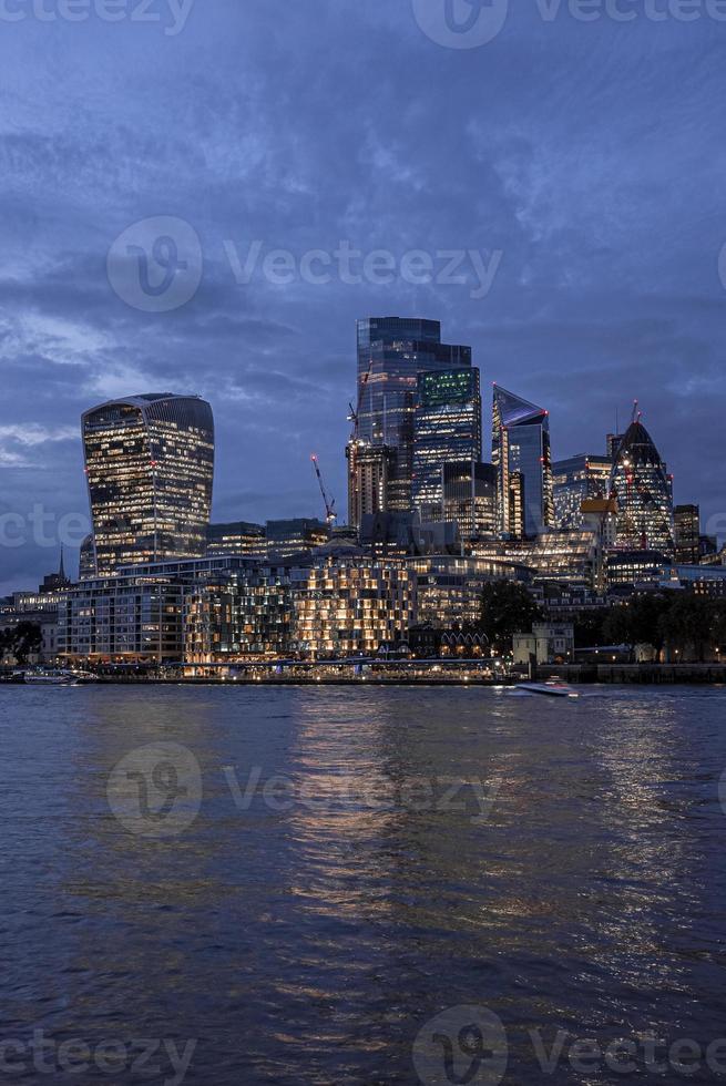 vista dos arranha-céus iluminados do distrito financeiro moderno do rio Tamisa foto