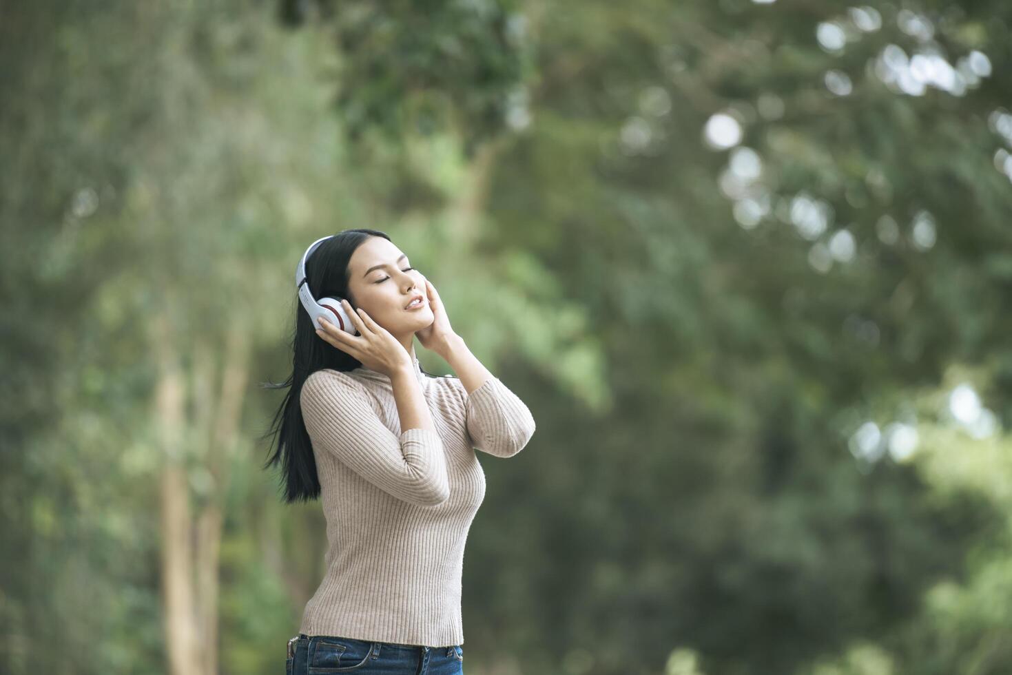 mulher asiática ouvindo música favorita em fones de ouvido. tempo feliz e relaxe. foto