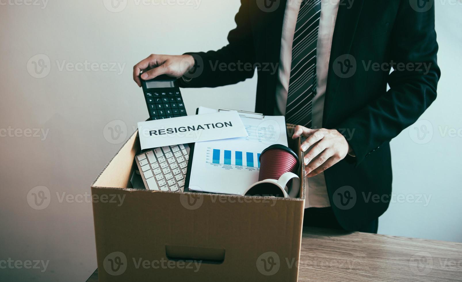 funcionários do sexo masculino estão mantendo seus próprios itens na mesa porque estão prestes a pedir demissão com o gerente. foto