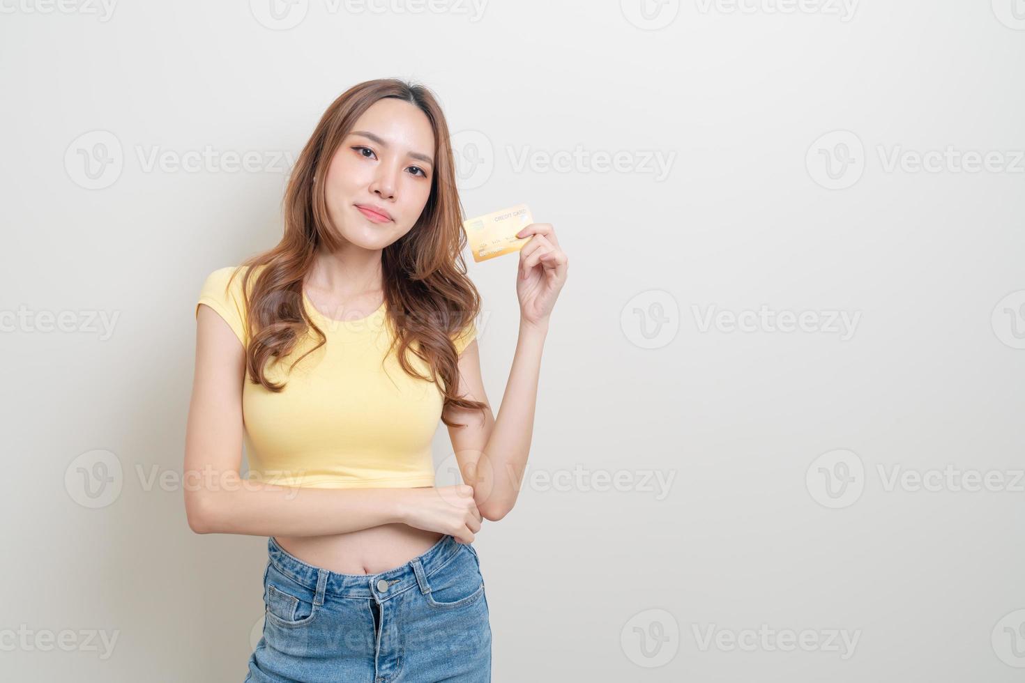 retrato linda mulher asiática segurando um cartão de crédito foto