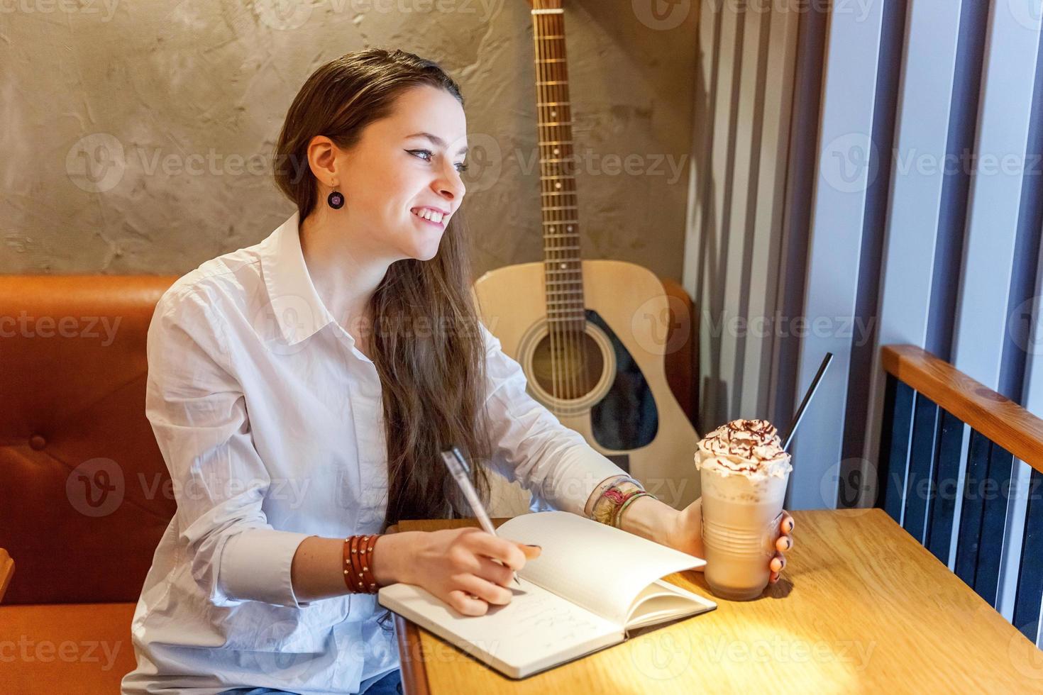 menina tocando violão no café foto