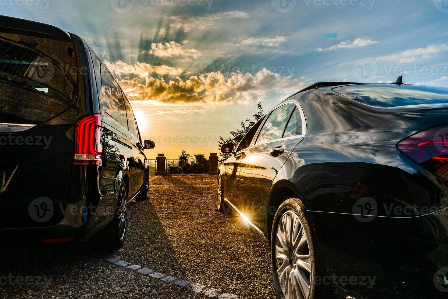 dois carros de luxo de frente para o pôr do sol colorido, grande angular foto