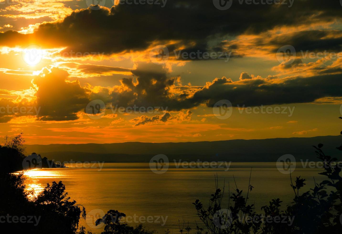lindas cores do pôr do sol sobre o lago genebra, o reflexo do sol poente na água, a atmosfera de paz e tranquilidade foto