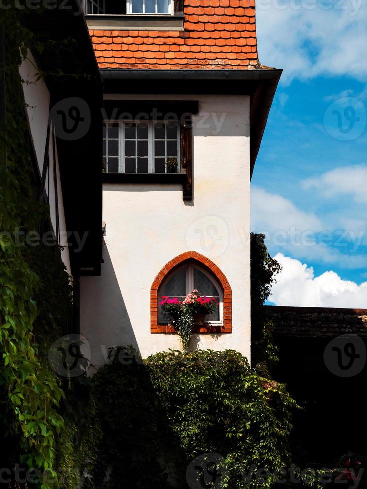 as casinhas de gengibre ensolaradas da Alsácia. telhados de telhas, flores ao redor, o sol de verão está brilhando. beleza. foto