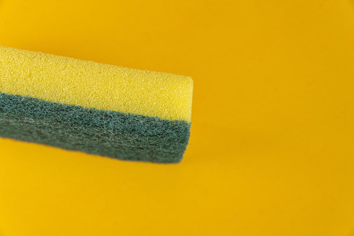 esponja de cozinha no fundo amarelo foto