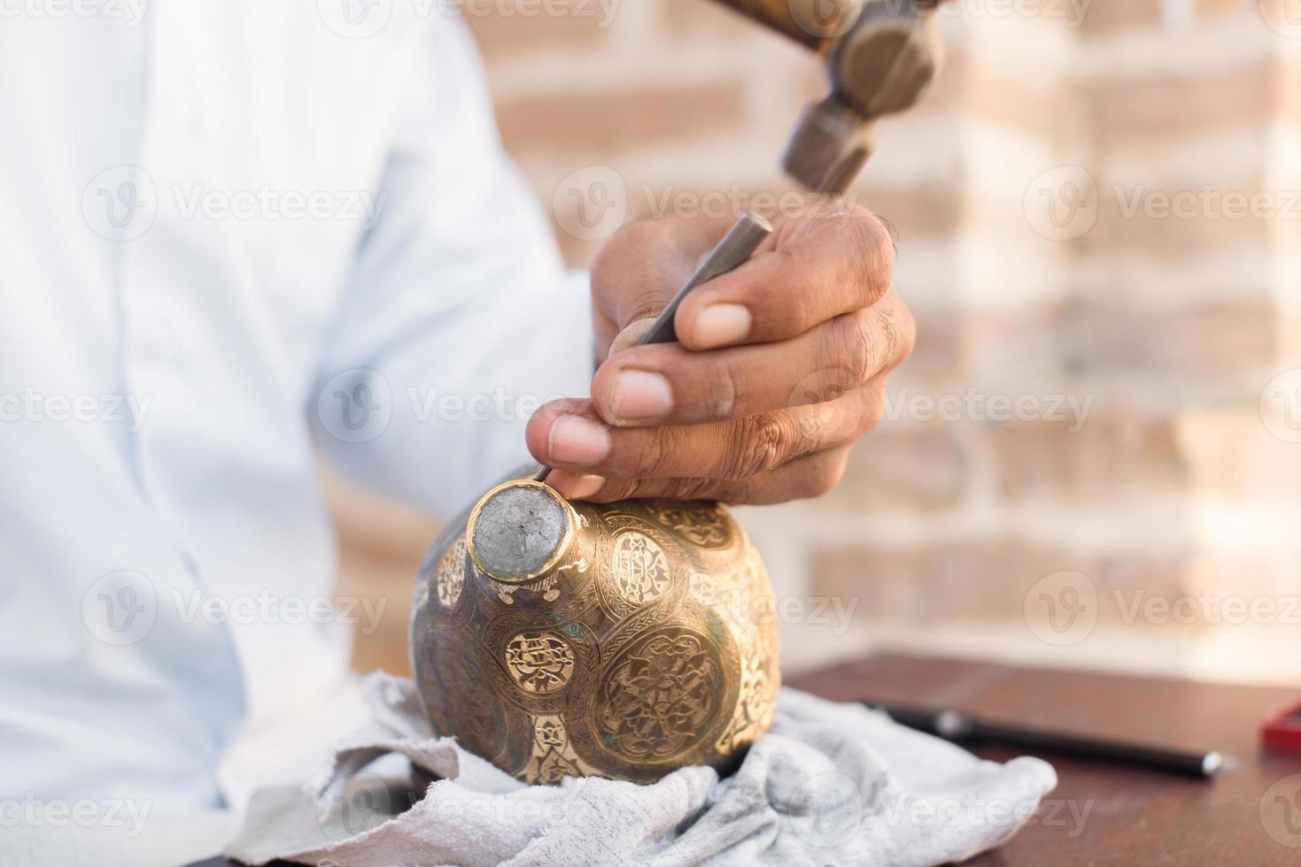padrões de gravura de artesão no jarro. mestres da Ásia Central. cunhagem manual de cobre foto