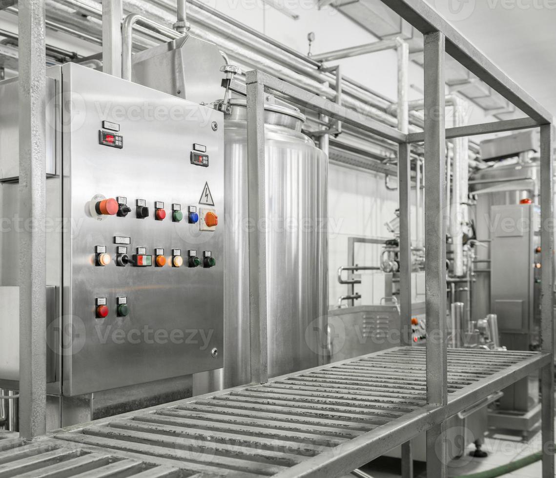 painel de controle eletrônico e tanque em uma fábrica de leite. equipamentos na fábrica de laticínios foto