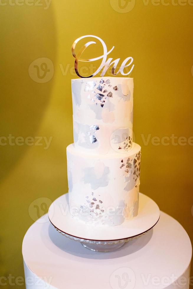 bolo elegante para o primeiro aniversário com uma inscrição prateada. bolo para o aniversário das crianças. foco seletivo foto