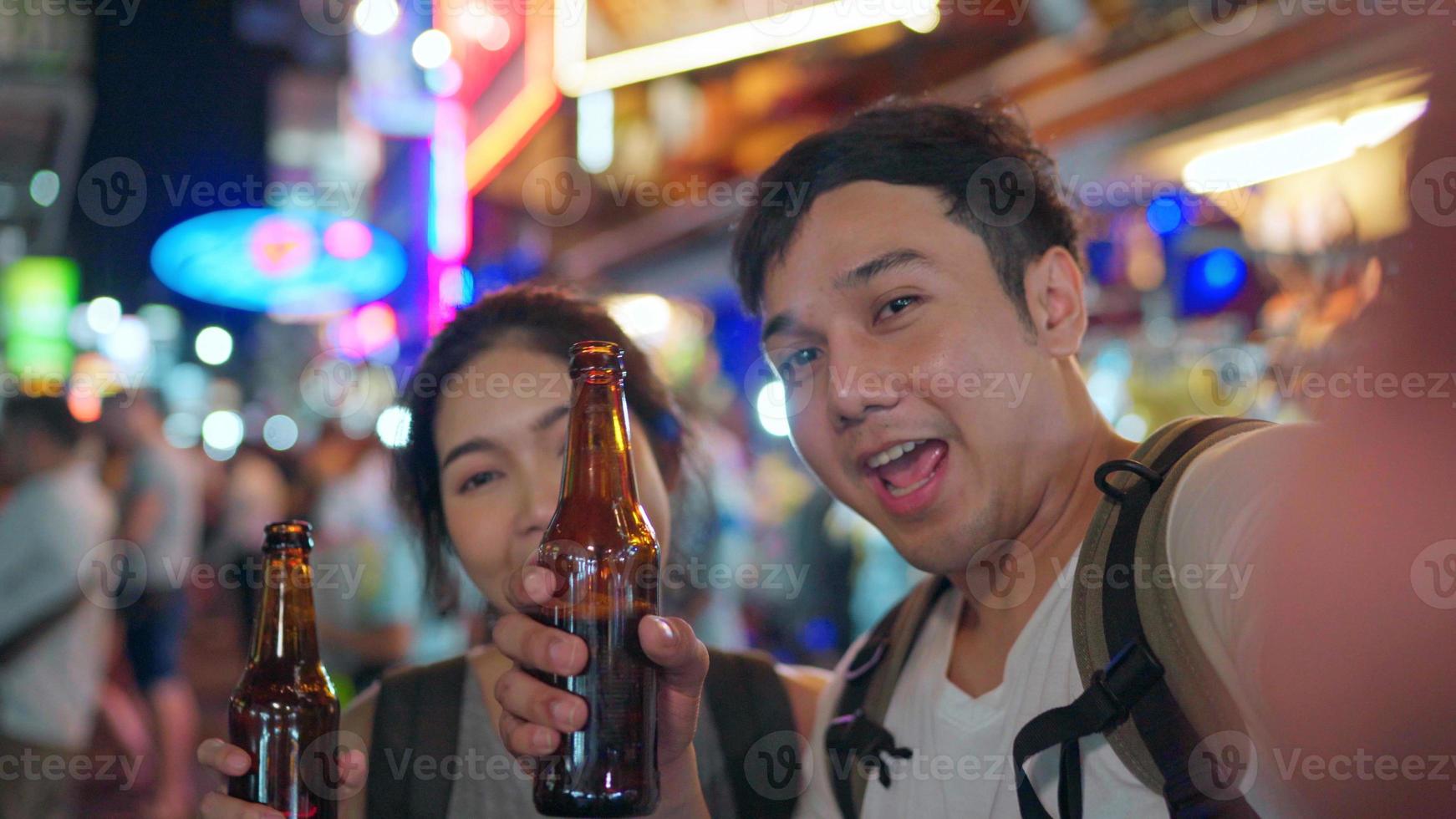 casal de blogueiros asiáticos viajam em bangkok, tailândia, casal doce usando telefone celular faz vlog e vive nas mídias sociais enquanto frequenta a estrada khao san. casal viaja no conceito de tailândia. foto