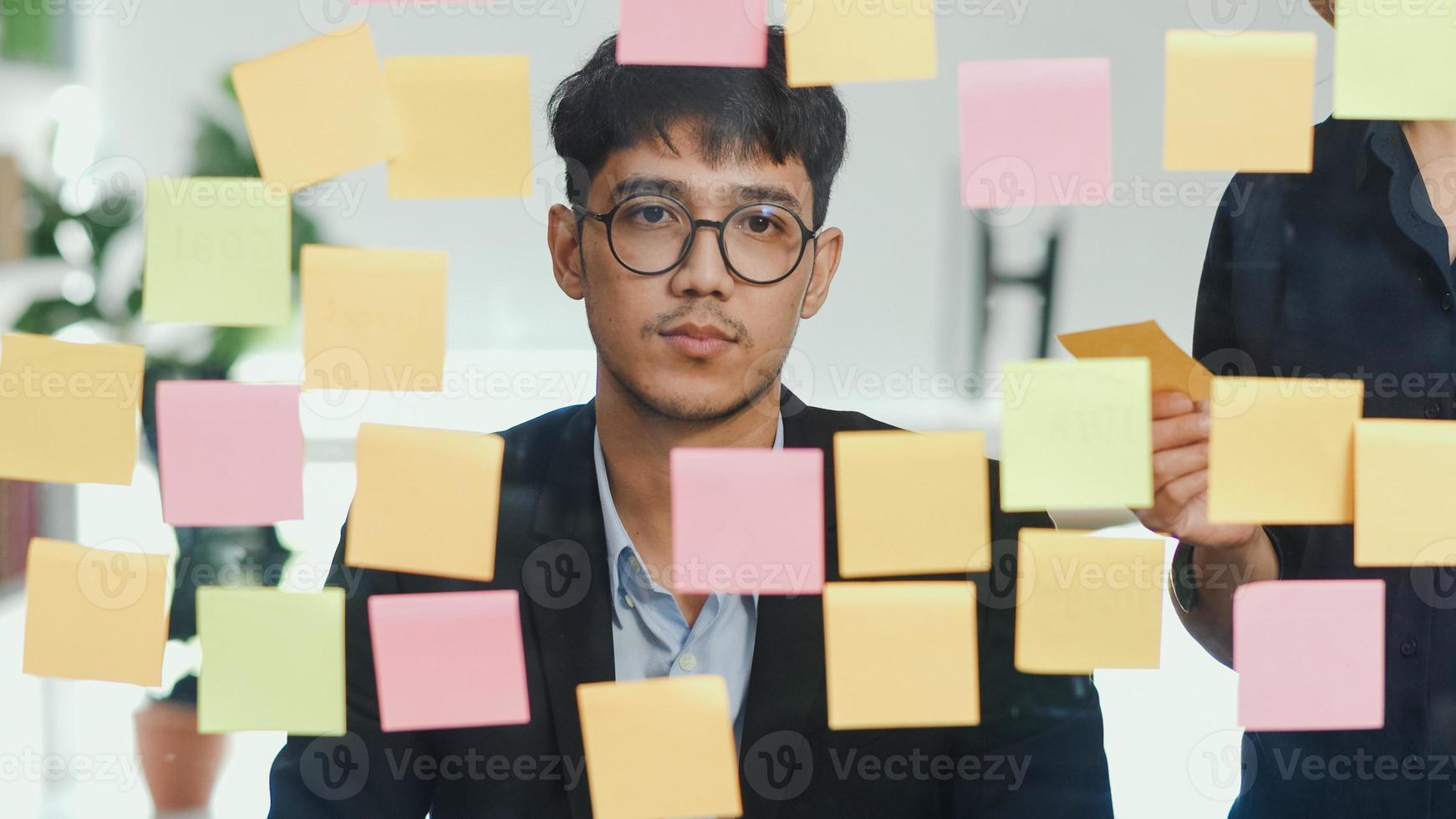 grupo de oficina de homens criativos asiáticos e brainstorming na frente da placa de espelho. equipe de negócios profissional jovem trabalhando criar estratégia, situação de negócios, inicialização no conceito de escritório loft. foto