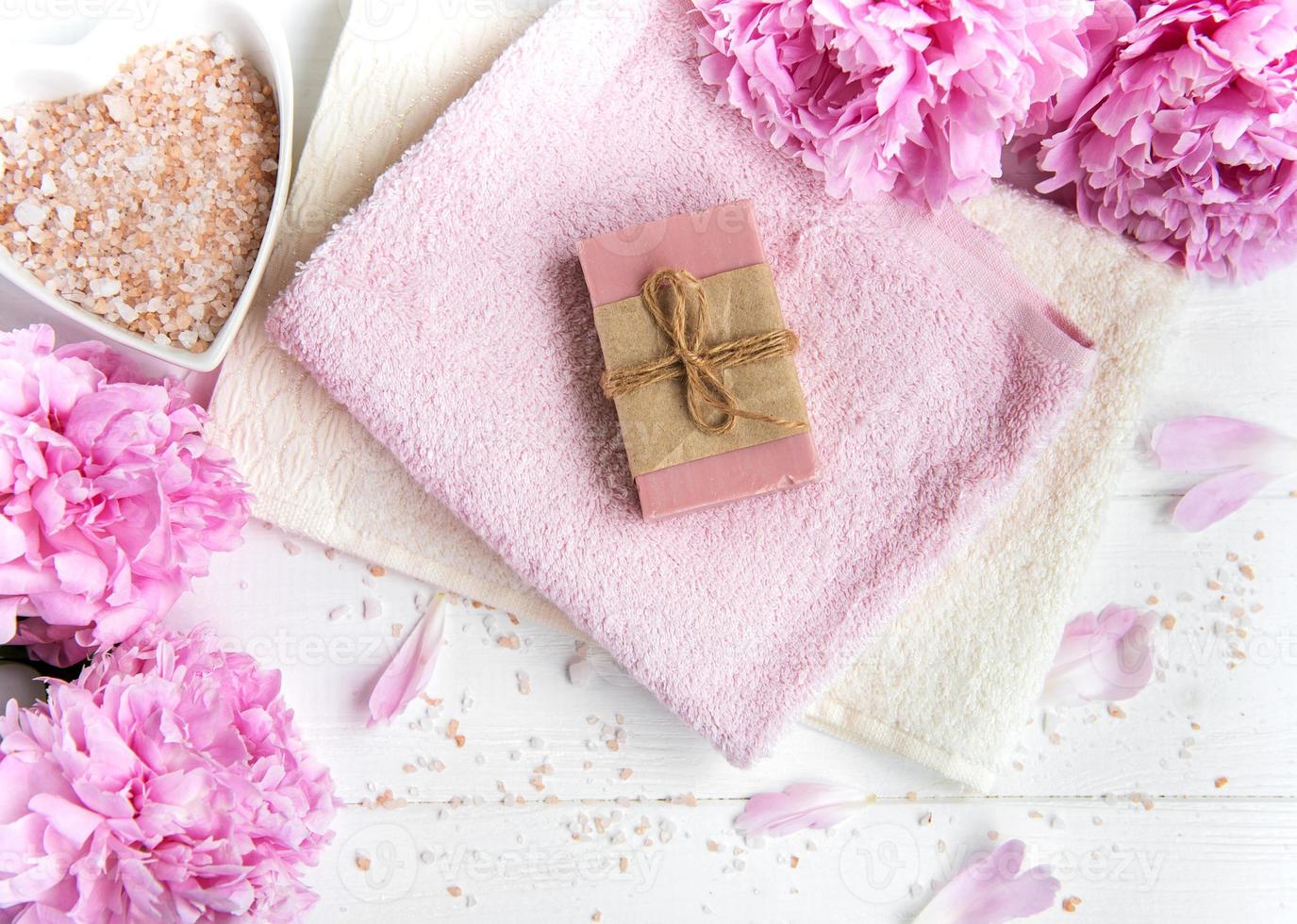 barras de sabonete artesanal, toalhas macias e flores de peônia foto