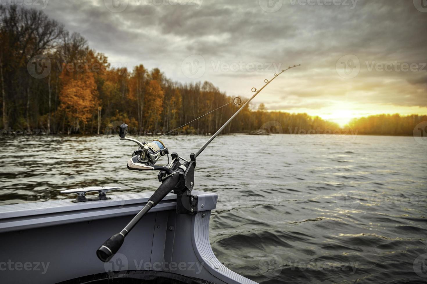 vara de pescar no barco. estação do outono. vara de pescar no barco, hora do pôr do sol. lindas cores de outono. uma vara de pescar é uma vara longa e flexível usada pelos pescadores para pescar. foto