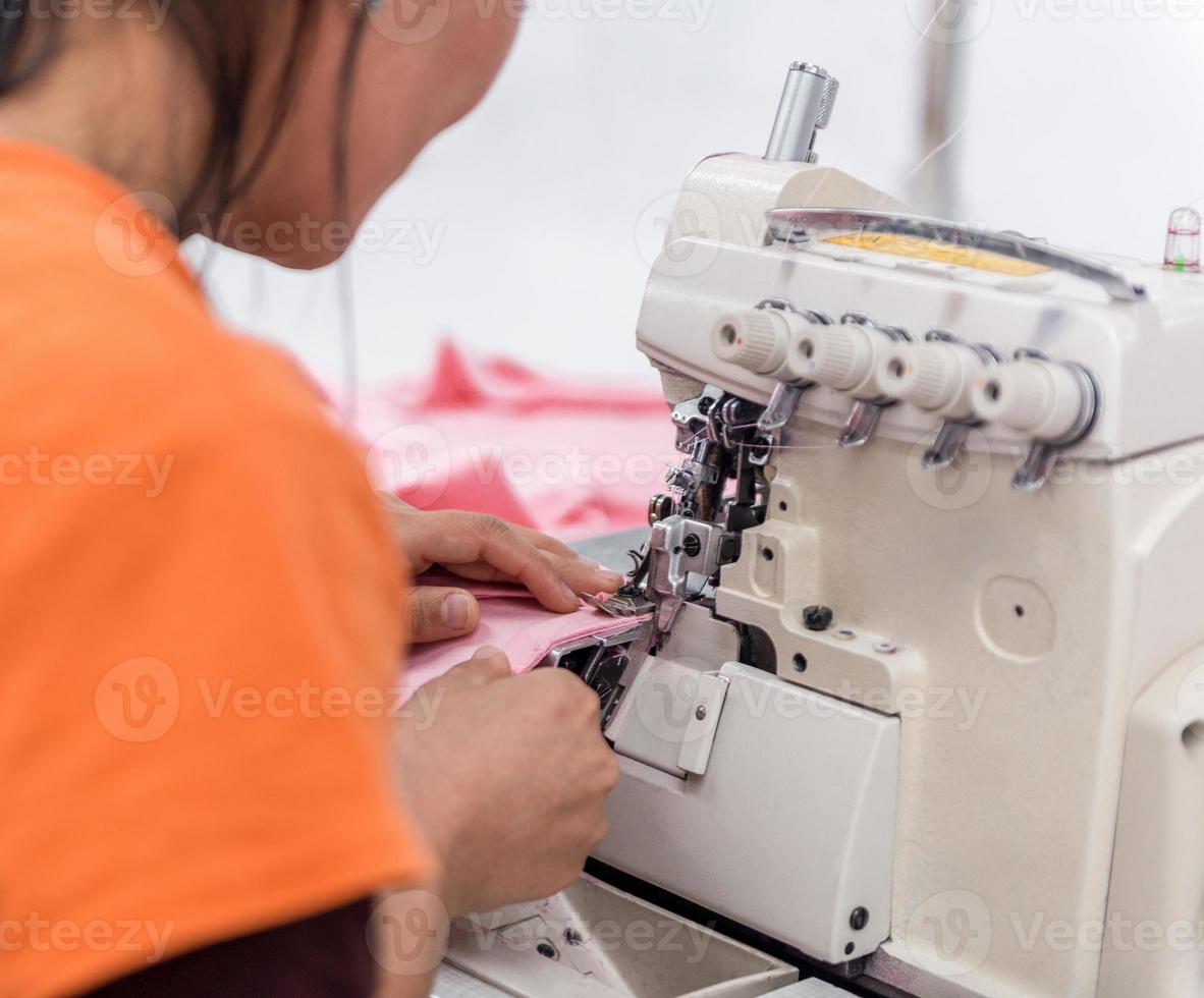 costureira na máquina costura roupas em uma fábrica de roupas. oficina têxtil foto