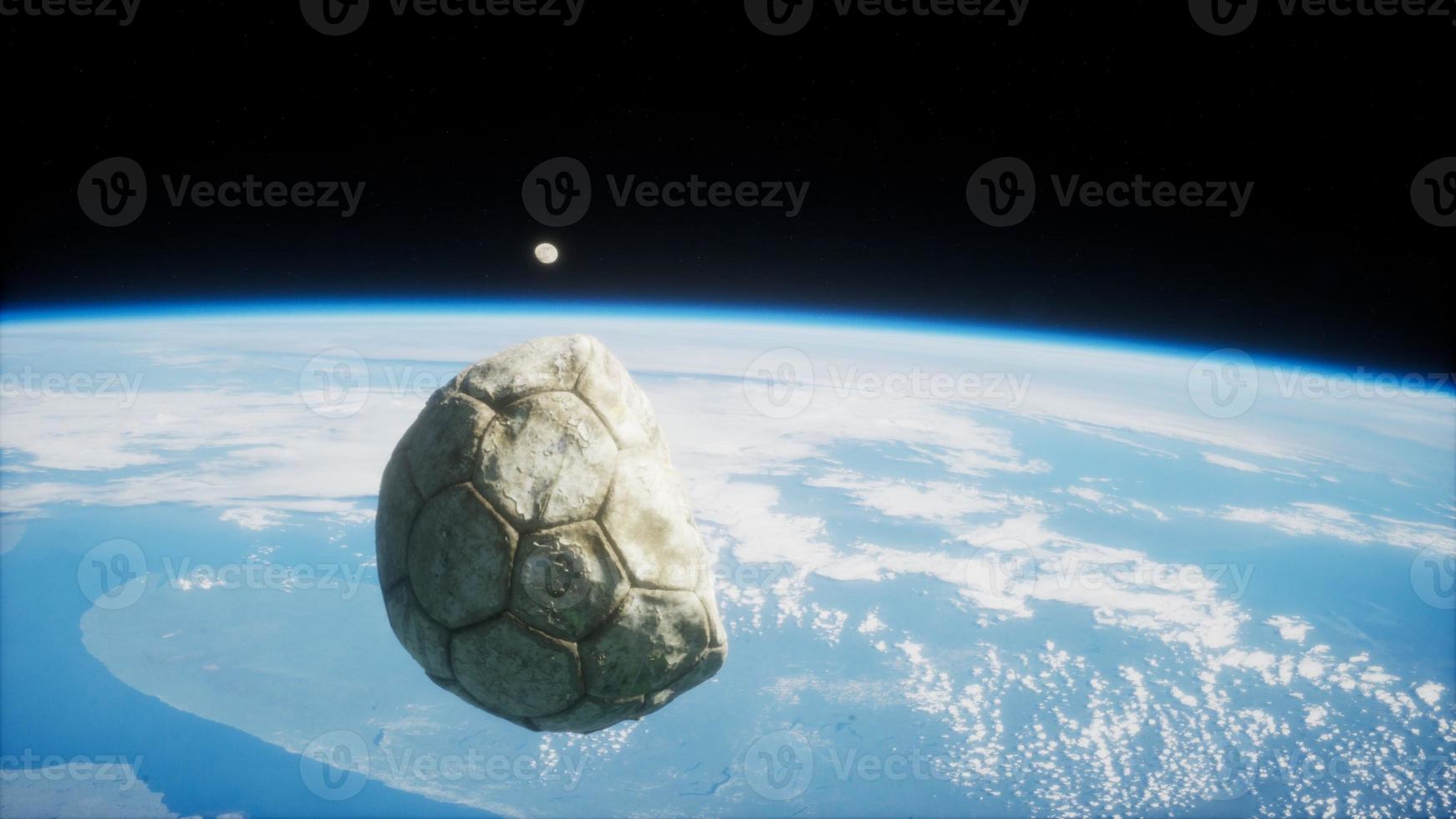 bola de futebol velha no espaço na órbita da terra foto