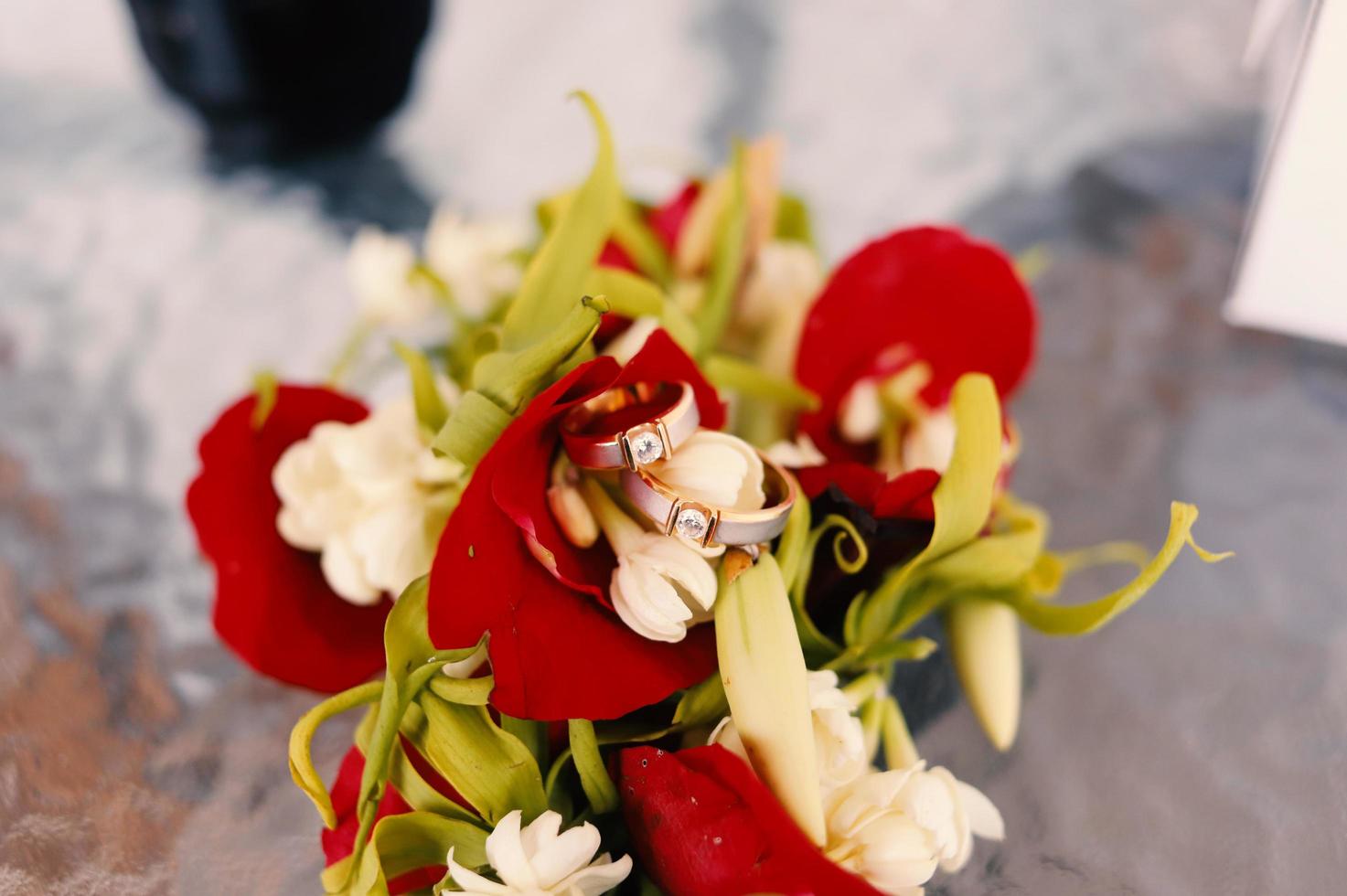 um par de anéis de casamento em um buquê de flores foto