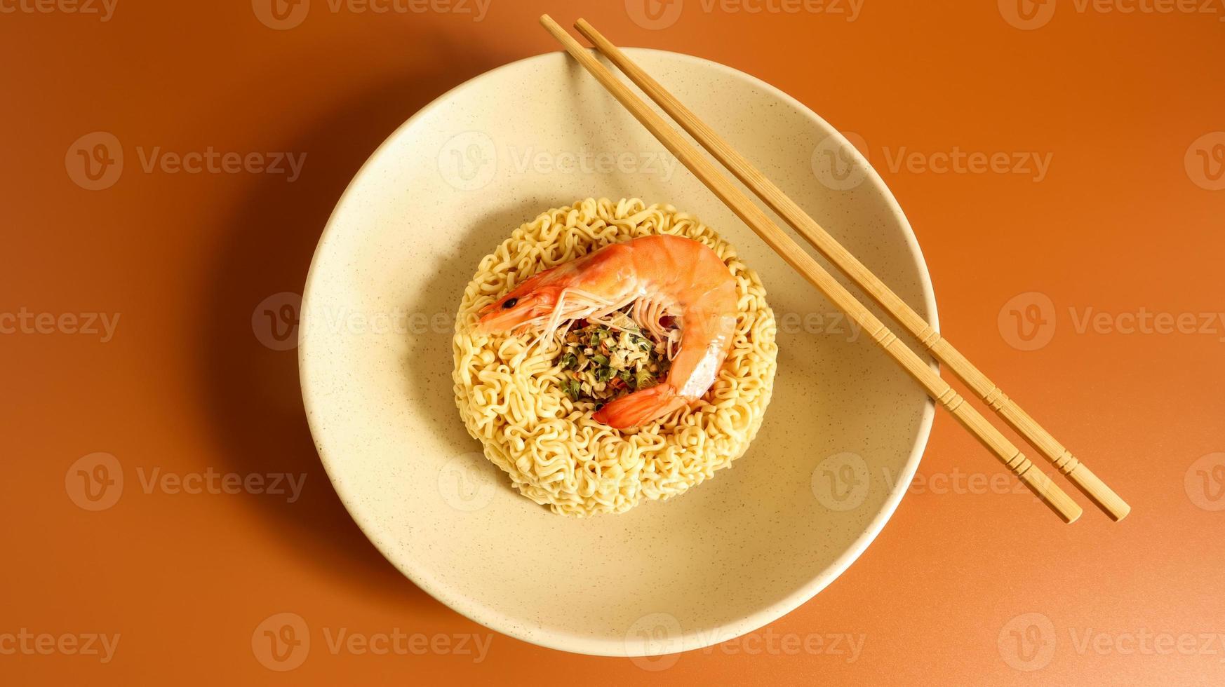 sopa de macarrão instantâneo picante com camarão. sopa de camarão, culinária, comida. aletria crua seca em forma de círculo em um prato. comida asiática. macarrão, para cuja preparação é suficiente derramar água fervente foto