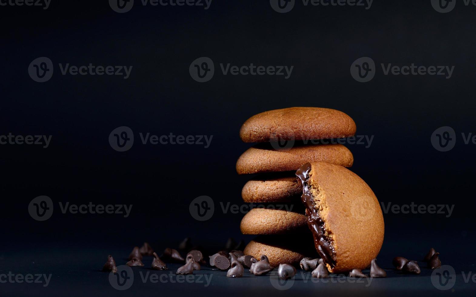 biscoitos - pilha de deliciosos biscoitos de creme recheados com creme de chocolate em fundo preto foto