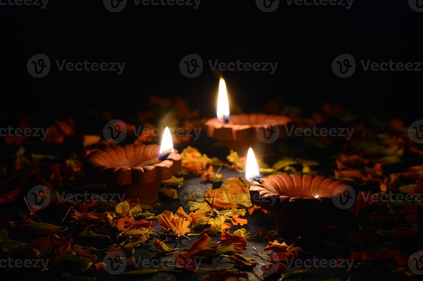 lâmpadas diya de argila acesas durante a celebração do diwali. projeto de cartão de saudações festival indiano da luz hindu chamado diwali foto