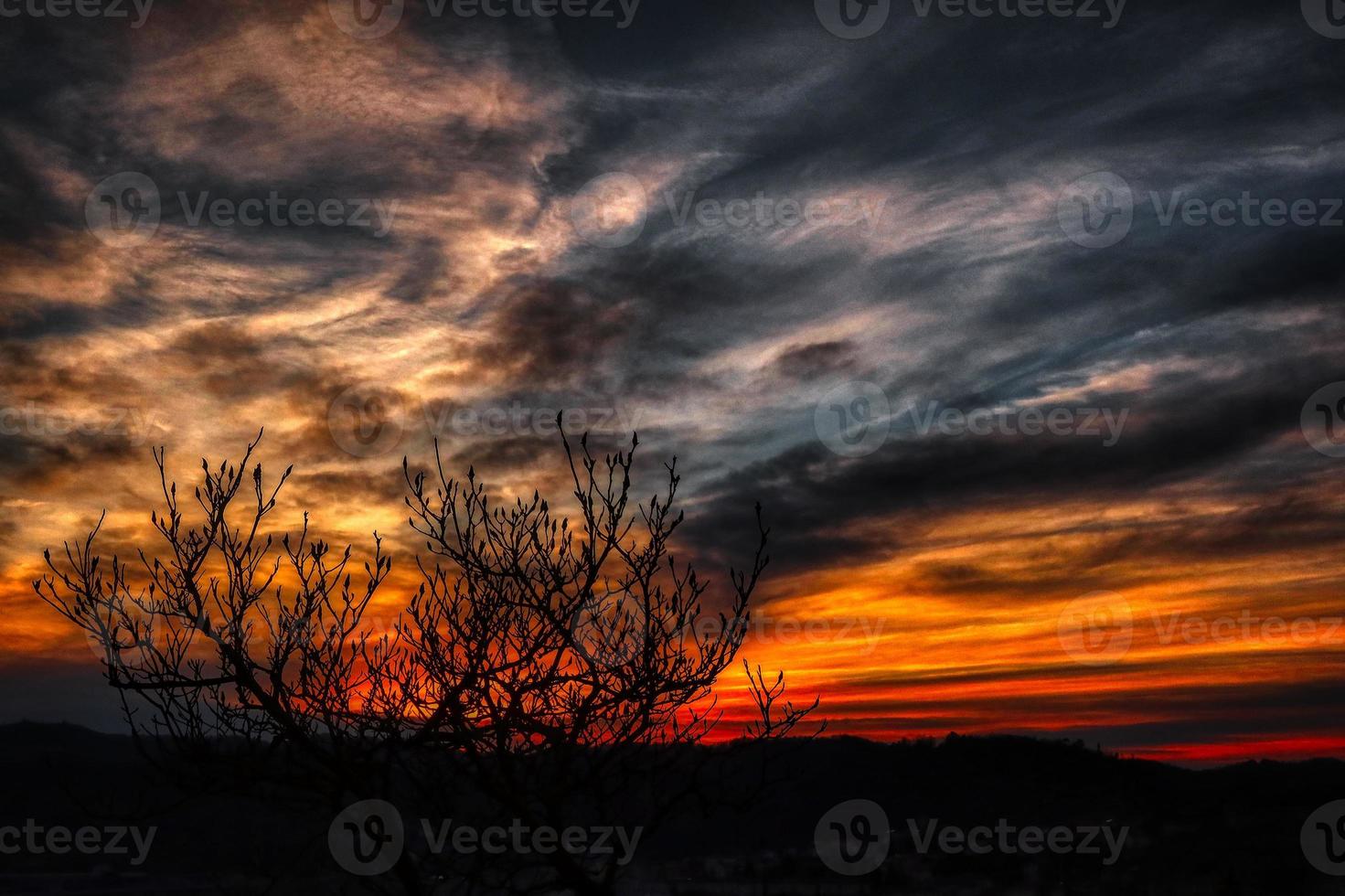 belo pôr do sol de um vermelho ardente com tons de amarelo dourado com nuvens refletindo essas cores esplêndidas do sol foto