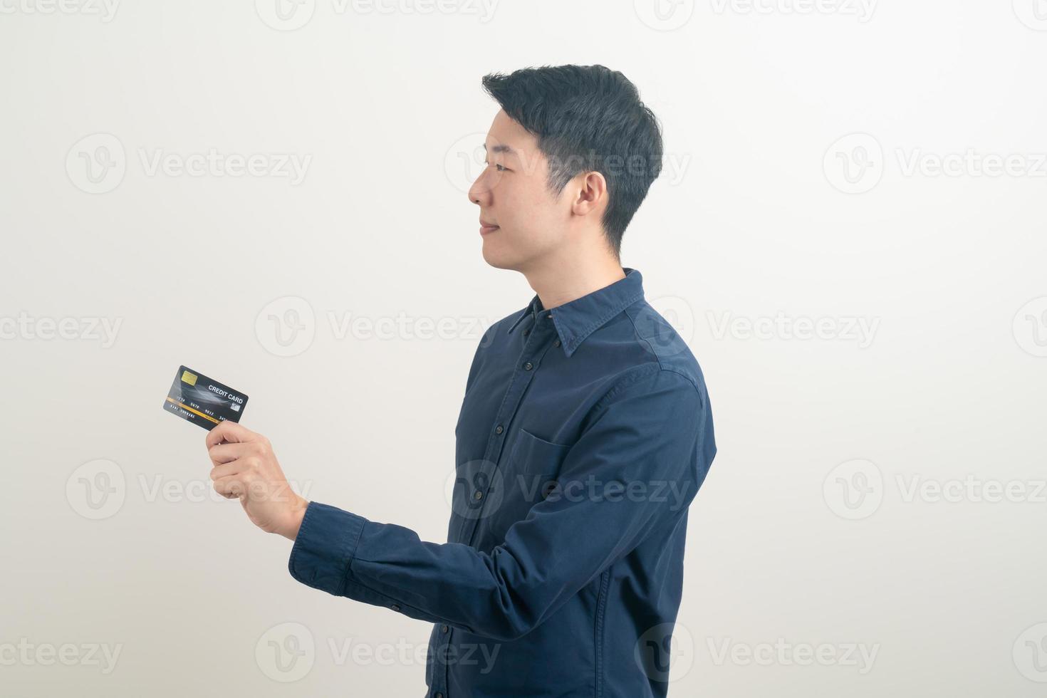 jovem asiático segurando um cartão de crédito foto