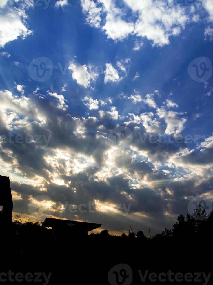 nuvens fofas brancas e cinzentas no céu azul com luz da manhã foto