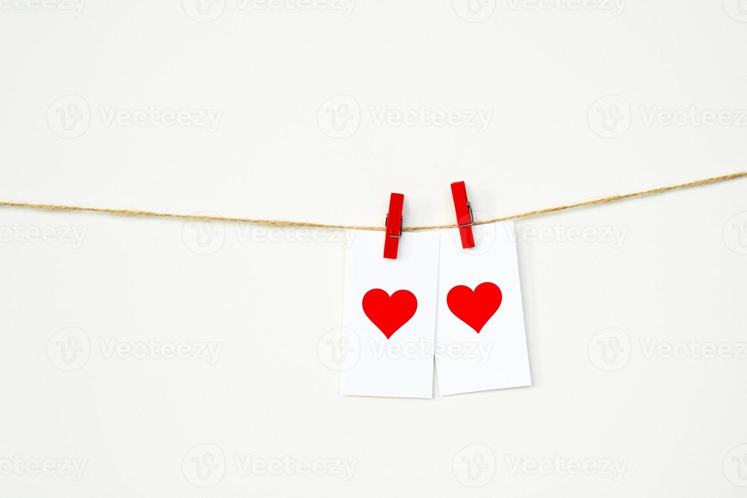 feliz Dia dos namorados. 2 cartões com corações vermelhos pendurados em uma corda em prendedores de roupa. combinação perfeita, amor foto