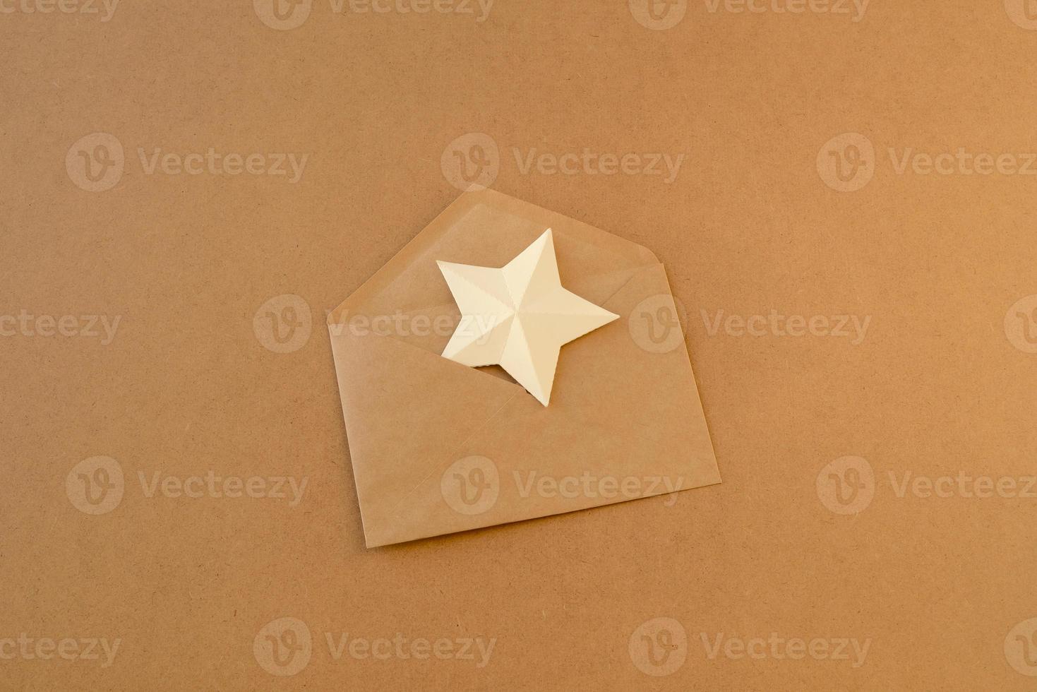 estrela de papel branco em um envelope feito de papel kraft marrom. asterisco no envelope. carta com estrela de papel foto