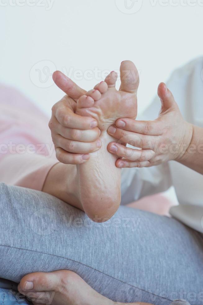 mãos fazendo massagem tailandesa nos pés. medicina alternativa e conceito de massagem tailandesa foto