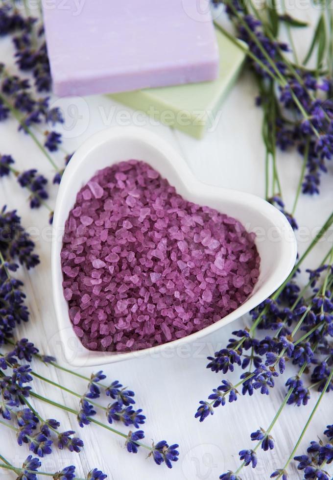 tigela em forma de coração com sal marinho, sabonete e flores frescas de lavanda foto