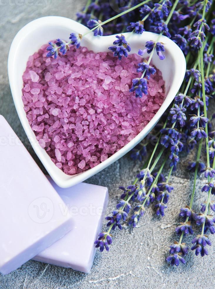 tigela em forma de coração com sal marinho, sabonete e flores frescas de lavanda foto