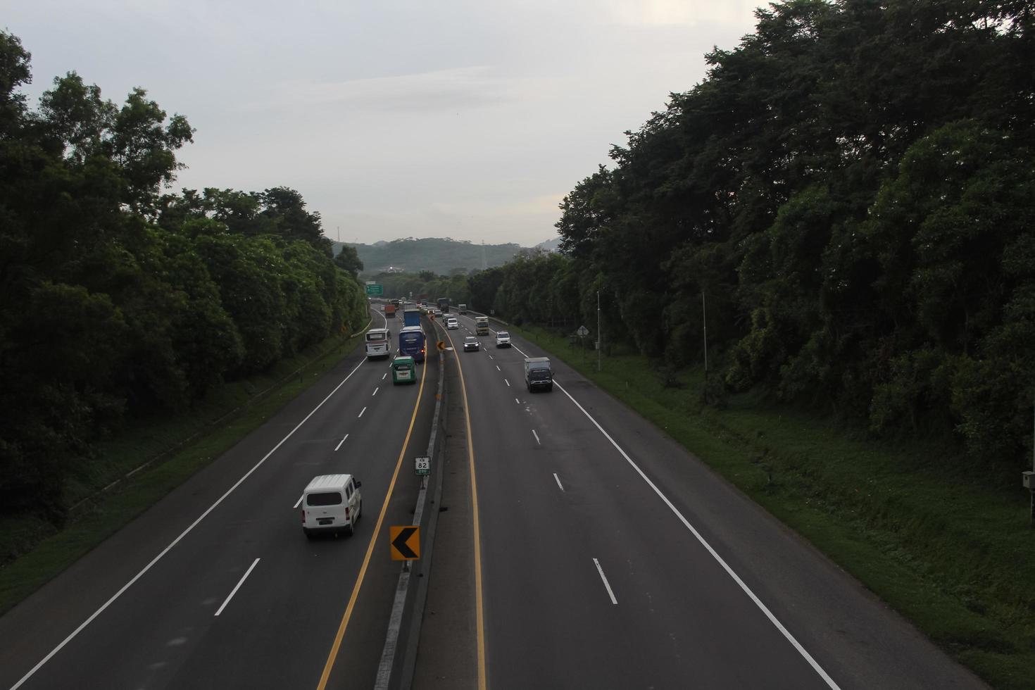 estrada com pedágio com muitas árvores à esquerda e à direita foto