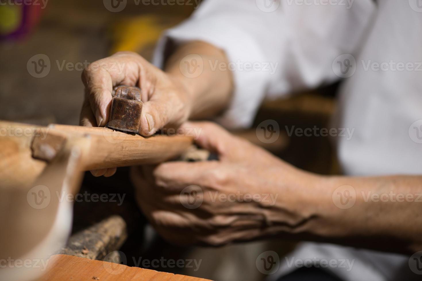 mestre adulto restaura instrumentos musicais antigos. escultura em madeira foto