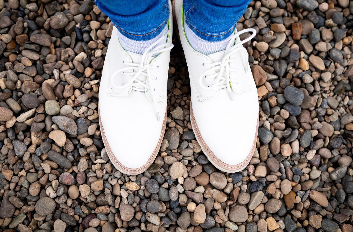 pés das mulheres em sapatos de rua, de pé sobre as pedras. foto