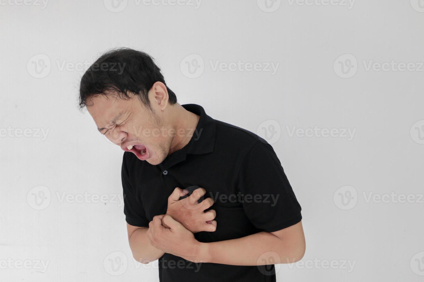ataque cardíaco ou coração partido de jovem asiático com emoção ferida usar camisa preta foto