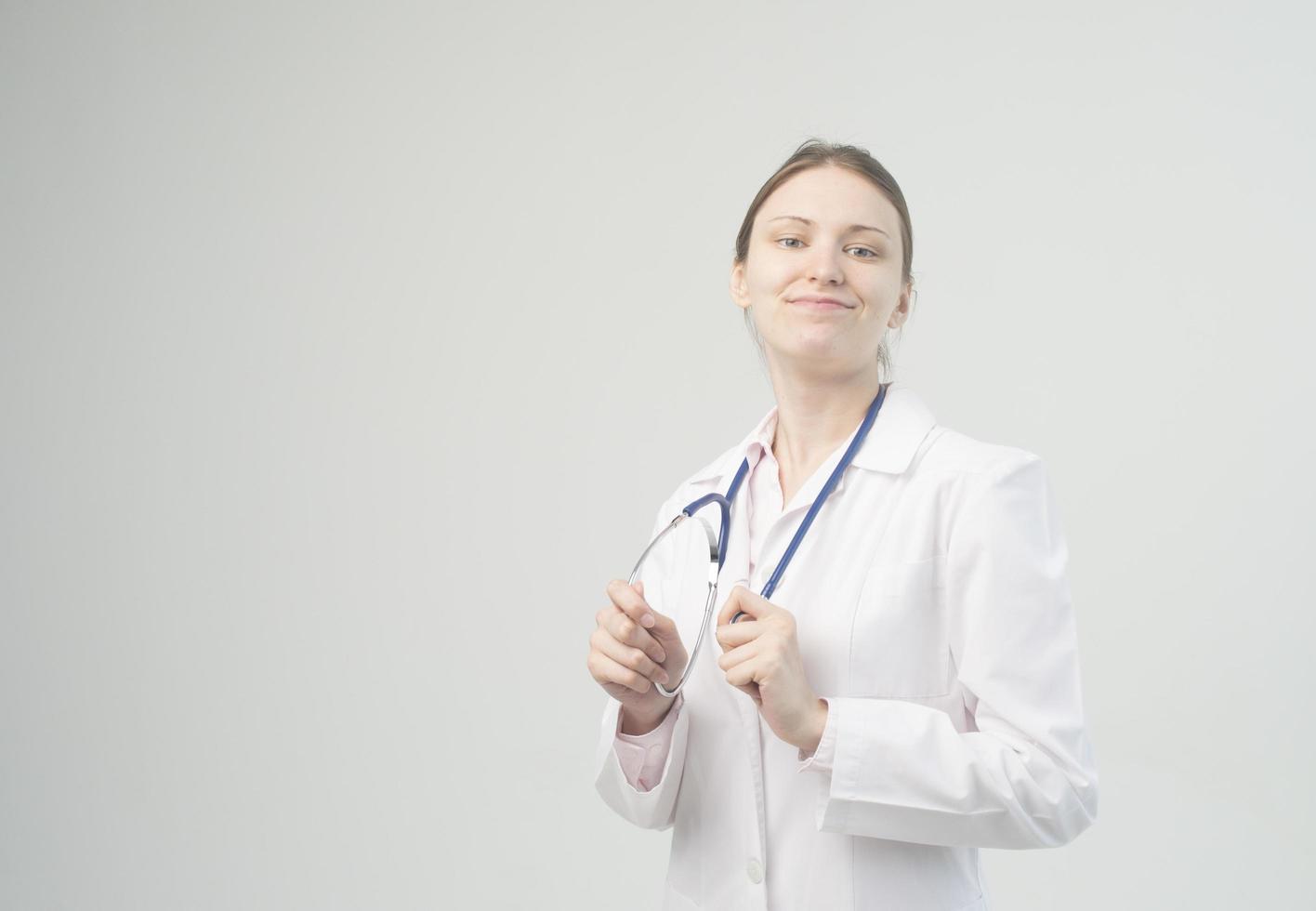 retrato de uma jovem médica atraente de jaleco branco. foto