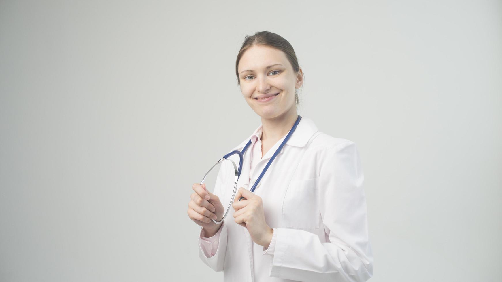 retrato de uma jovem médica atraente de jaleco branco. foto