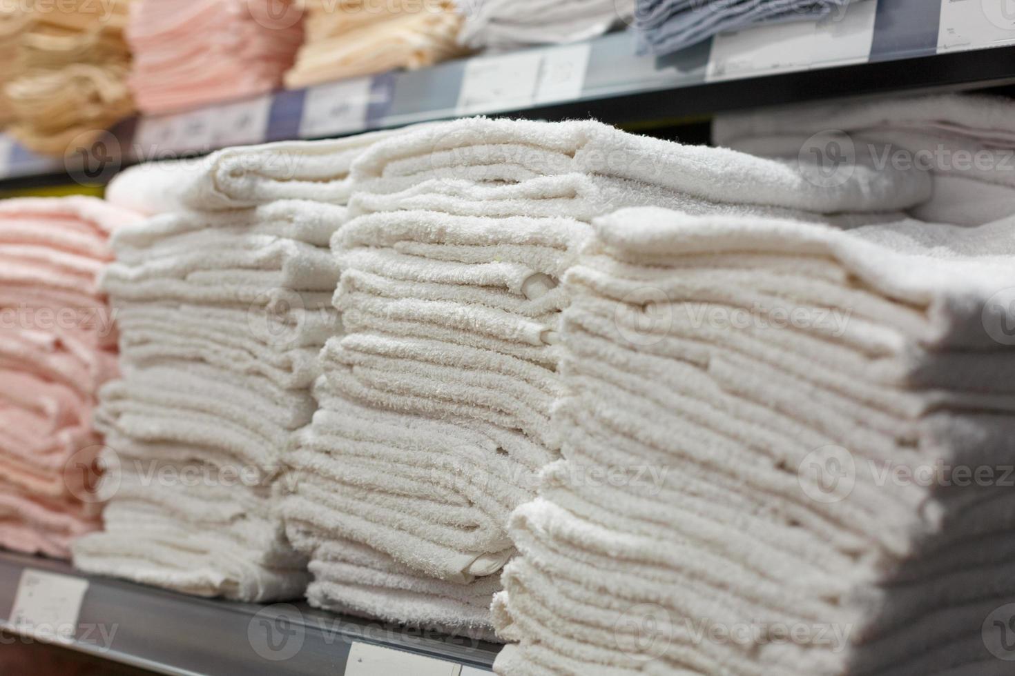 toalhas leves em pilhas na prateleira da loja foto
