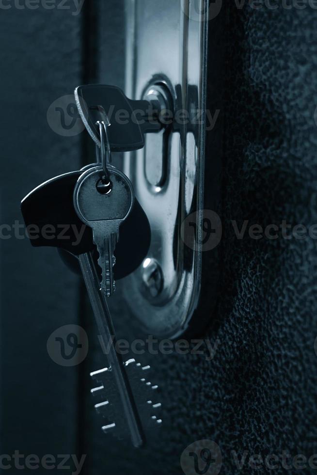 molho de chaves no buraco da fechadura da porta foto