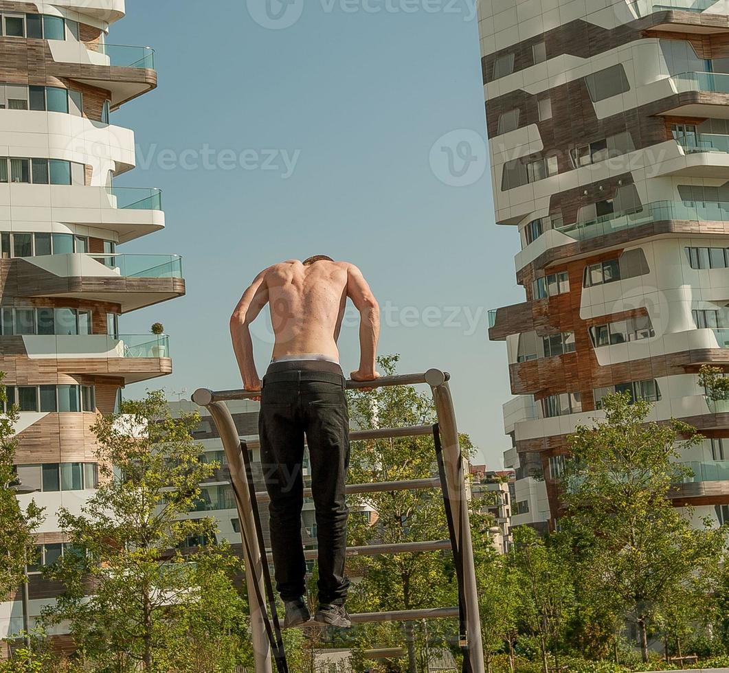 milão itália 2017 menino que faz ginástica no parque do novo distrito citylife um dos maiores parques de milão foto